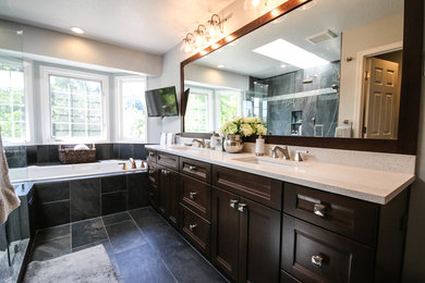 Example of a mid-sized transitional master multicolored tile and porcelain tile porcelain tile bathroom design in Portland with recessed-panel cabinets, brown cabinets, a two-piece toilet, gray walls, an undermount sink and quartz countertops