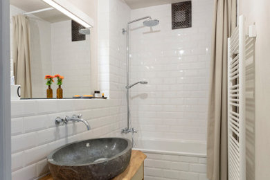 Kleines Modernes Duschbad mit Einbaubadewanne, weißen Fliesen, Metrofliesen, Zementfliesen für Boden, Aufsatzwaschbecken, Waschtisch aus Holz, Duschvorhang-Duschabtrennung, Einzelwaschbecken und freistehendem Waschtisch in Köln