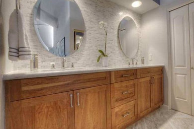 Inspiration for a mid-sized modern master white tile and glass tile marble floor corner shower remodel in San Diego with shaker cabinets, brown cabinets, a two-piece toilet, an undermount sink and a hinged shower door