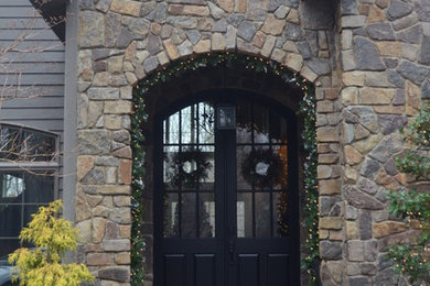 Inspiration for a large timeless gray two-story stone gable roof remodel in Grand Rapids