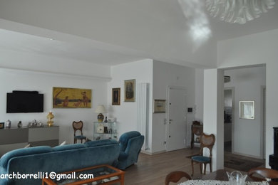 Esempio di un ampio soggiorno moderno aperto con pareti bianche, pavimento in laminato, TV a parete e pavimento beige