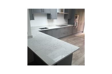 Photo of a medium sized contemporary kitchen/diner in Essex with a submerged sink, quartz worktops and a breakfast bar.