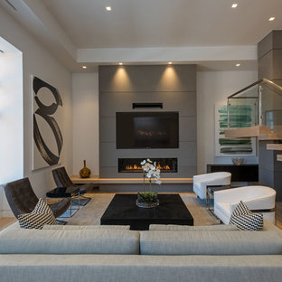 Bild på ett funkis allrum med öppen planlösning, med vita väggar, mellanmörkt trägolv, en bred öppen spis, en väggmonterad TV och brunt golv