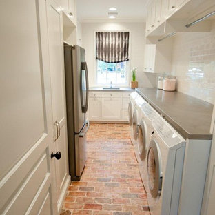 This is an example of a traditional utility room in Houston with brick flooring and red floors.