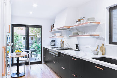 Enclosed kitchen - small contemporary galley light wood floor enclosed kitchen idea in Toronto with an undermount sink, flat-panel cabinets, quartz countertops, white backsplash, stone slab backsplash, paneled appliances and no island