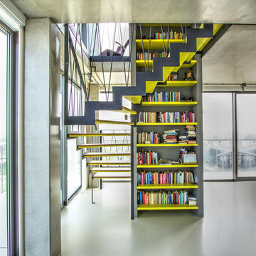 Moderne, halbgewendelte Podesttreppe mit Stahlwangen & integriertem Bücherregal