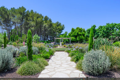 Inspiration pour un jardin à la française avant méditerranéen avec un chemin, une exposition ensoleillée et des pavés en pierre naturelle.
