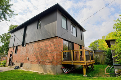 Mid-sized black two-story metal and board and batten house exterior photo in Toronto with a black roof