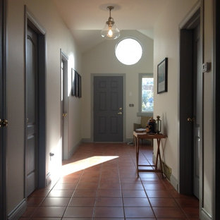 Exempel på en stor eklektisk hall, med vita väggar, klinkergolv i terrakotta, en enkeldörr och en grå dörr