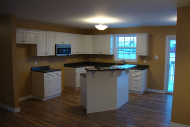 Example of a mid-sized l-shaped medium tone wood floor kitchen design in Other with a double-bowl sink, laminate countertops and an island