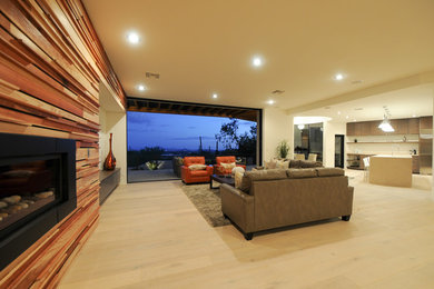 Living room - large transitional open concept light wood floor living room idea in Phoenix with a standard fireplace and a wood fireplace surround