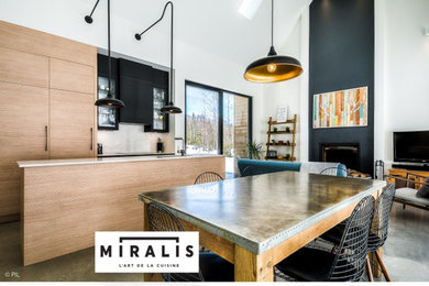 Small urban l-shaped concrete floor open concept kitchen photo in Montreal with flat-panel cabinets, medium tone wood cabinets, quartz countertops, white backsplash, marble backsplash, stainless steel appliances, an island and white countertops