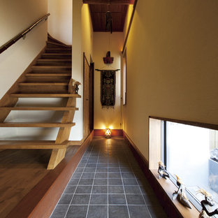 他の地域のアジアンスタイルのおしゃれな玄関 (ベージュの壁、黒い床) の写真