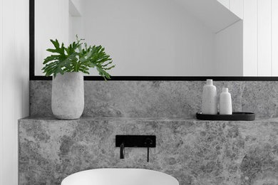 This is an example of a large contemporary powder room in Sydney with a one-piece toilet, white tile, white walls, ceramic floors, a pedestal sink, marble benchtops, grey floor and grey benchtops.