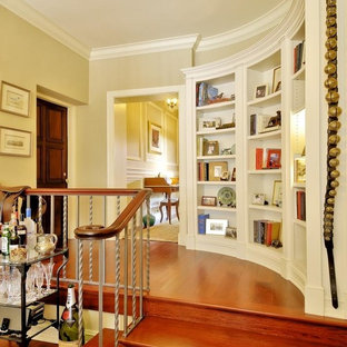 Klassisk inredning av en mellanstor hall, med beige väggar och mellanmörkt trägolv