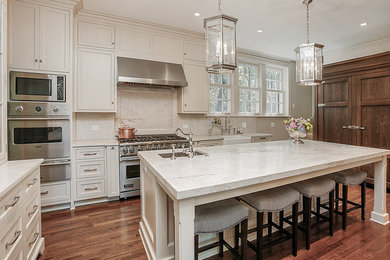 Kitchen - large traditional dark wood floor kitchen idea in Chicago with a farmhouse sink, shaker cabinets, dark wood cabinets, quartzite countertops, stone slab backsplash and paneled appliances