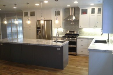 Example of a mid-sized arts and crafts l-shaped light wood floor eat-in kitchen design in Salt Lake City with an undermount sink, shaker cabinets, white cabinets, quartzite countertops, gray backsplash, subway tile backsplash, stainless steel appliances and an island