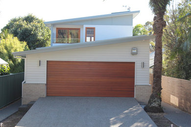 Mid-sized beach style two-storey white exterior in Newcastle - Maitland with mixed siding and a flat roof.