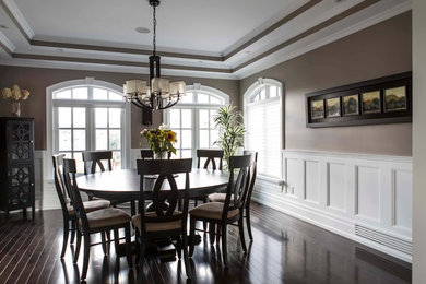 Inspiration for a large transitional dark wood floor enclosed dining room remodel in Toronto with brown walls