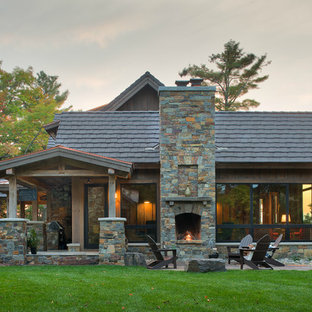 На фото: огромные, трехэтажные фасады частных домов коричневого цвета в стиле рустика с комбинированной облицовкой, двускатной крышей и крышей из смешанных материалов