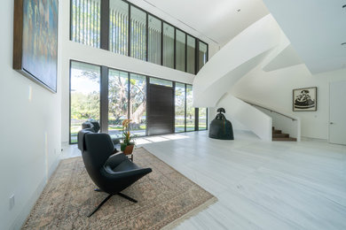 Inspiration for a large contemporary concrete floor and white floor entryway remodel with white walls and a medium wood front door