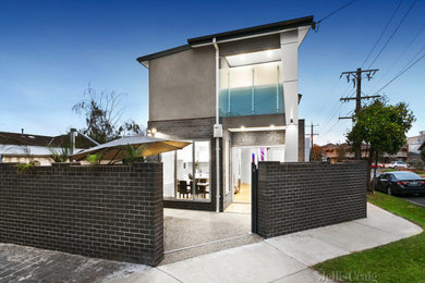 Photo of a mid-sized modern side yard and ground level deck in Melbourne with with privacy feature and an awning.