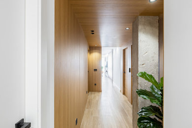 Ejemplo de recibidores y pasillos mediterráneos de tamaño medio con paredes marrones, suelo de madera clara, madera, madera y iluminación