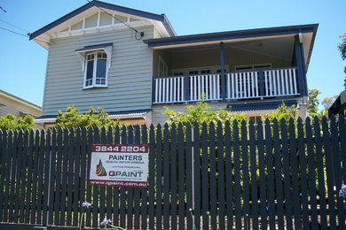 Photo of a mid-sized traditional one-storey grey exterior in Brisbane with wood siding.