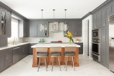 Mid-sized transitional u-shaped porcelain tile kitchen photo in Toronto with a double-bowl sink, shaker cabinets, gray cabinets, quartz countertops, white backsplash, glass tile backsplash, stainless steel appliances and an island