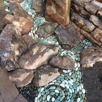 Dry laid patio with pebble stream and waterfall