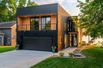 Example of a small minimalist black two-story concrete fiberboard and board and batten exterior home design with a black roof