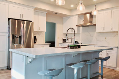Mid-sized transitional l-shaped laminate floor and beige floor eat-in kitchen photo in Orange County with an undermount sink, shaker cabinets, white cabinets, quartzite countertops, white backsplash, quartz backsplash, stainless steel appliances, an island and white countertops