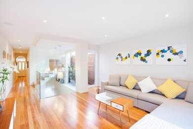 Photo of a mid-sized contemporary loft-style living room in Sydney with white walls and ceramic floors.