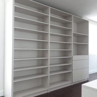 Exemple d'un grand dressing room moderne neutre avec un placard à porte vitrée, des portes de placard en bois clair, un sol en bois foncé, un sol marron et un plafond en lambris de bois.
