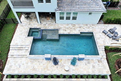 Hot tub - large contemporary backyard stone and rectangular hot tub idea in Orlando