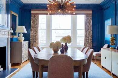 Inspiration for a transitional medium tone wood floor and beige floor dining room remodel in Sacramento with blue walls and a standard fireplace