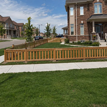 The fence turning the corner of the lot, with the sidewalk and street beyond, Ca