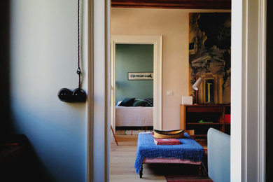 Ispirazione per un soggiorno eclettico di medie dimensioni e chiuso con pareti beige, pavimento in legno massello medio e travi a vista