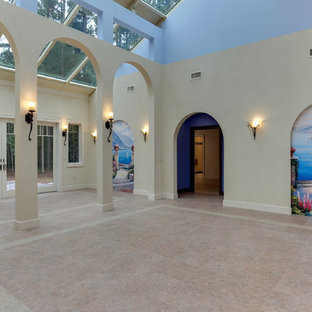 Modelo de salón abierto, mediterráneo, grande, sin chimenea y televisor, con paredes multicolor, suelo vinílico y suelo beige