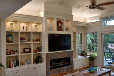 Family room - mid-sized traditional enclosed medium tone wood floor and brown floor family room idea in Atlanta with white walls, a ribbon fireplace, a tile fireplace and a wall-mounted tv