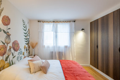 Cette image montre une chambre parentale style shabby chic de taille moyenne avec un mur beige, un sol en bois brun, aucune cheminée et un sol beige.
