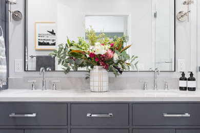 Example of a mid-sized transitional porcelain tile bathroom design in Los Angeles with shaker cabinets, gray cabinets, gray walls, a drop-in sink, quartz countertops and gray countertops