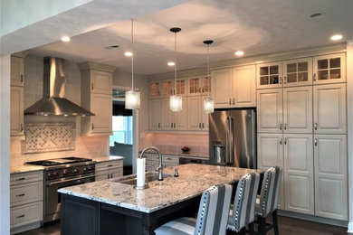 Example of a mid-sized transitional single-wall dark wood floor and brown floor eat-in kitchen design in Philadelphia with an undermount sink, raised-panel cabinets, beige cabinets, granite countertops, beige backsplash, subway tile backsplash, stainless steel appliances and an island