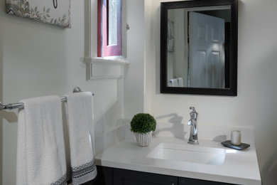 Idéer för små funkis vitt badrum med dusch, med luckor med profilerade fronter, svarta skåp, en toalettstol med separat cisternkåpa, vita väggar, cementgolv, ett undermonterad handfat och bänkskiva i akrylsten