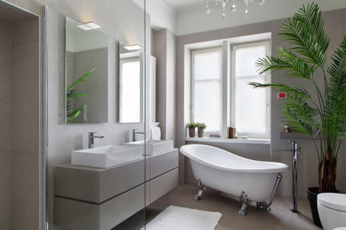 This is an example of a contemporary bathroom in Venice with flat-panel cabinets, grey cabinets, a claw-foot tub, grey walls, a vessel sink, grey floor, grey benchtops, a double vanity and a floating vanity.