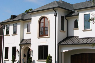Traditional white two-story stucco exterior home idea in Houston with a hip roof