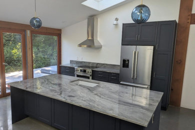Example of a minimalist l-shaped kitchen design with an undermount sink, quartzite countertops, gray backsplash, stainless steel appliances, an island and gray countertops