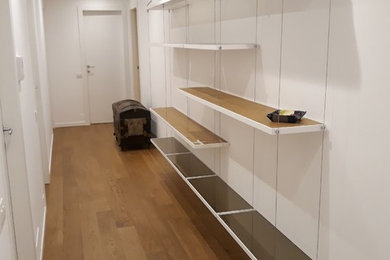 Immagine di un ingresso o corridoio moderno di medie dimensioni con pareti bianche, parquet chiaro e pavimento beige