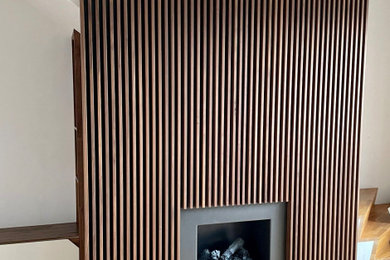 Ejemplo de salón abierto minimalista de tamaño medio con marco de chimenea de metal