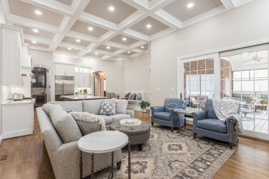 Inspiration for a large transitional open concept medium tone wood floor and coffered ceiling living room remodel in Raleigh with gray walls, a standard fireplace, a stacked stone fireplace and a media wall